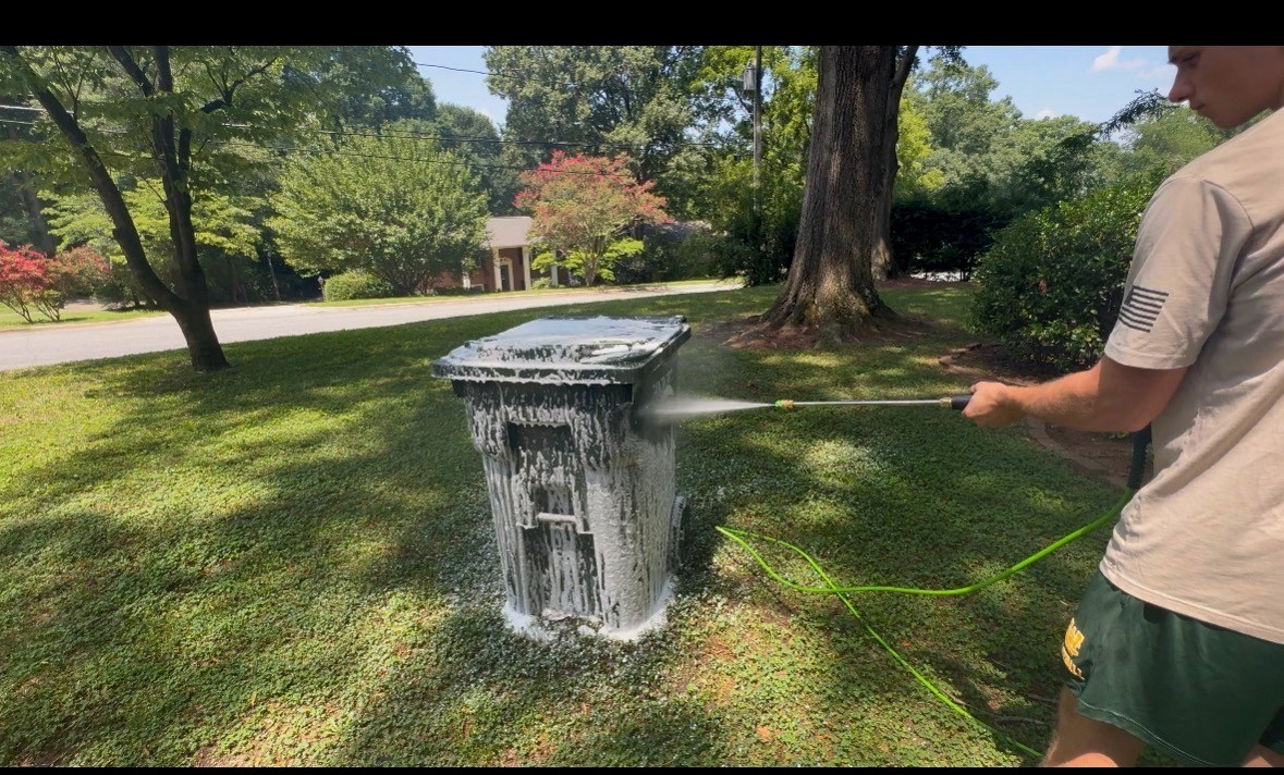 Can Clean teen pressure washing a foamy trash can in Hickory, NC